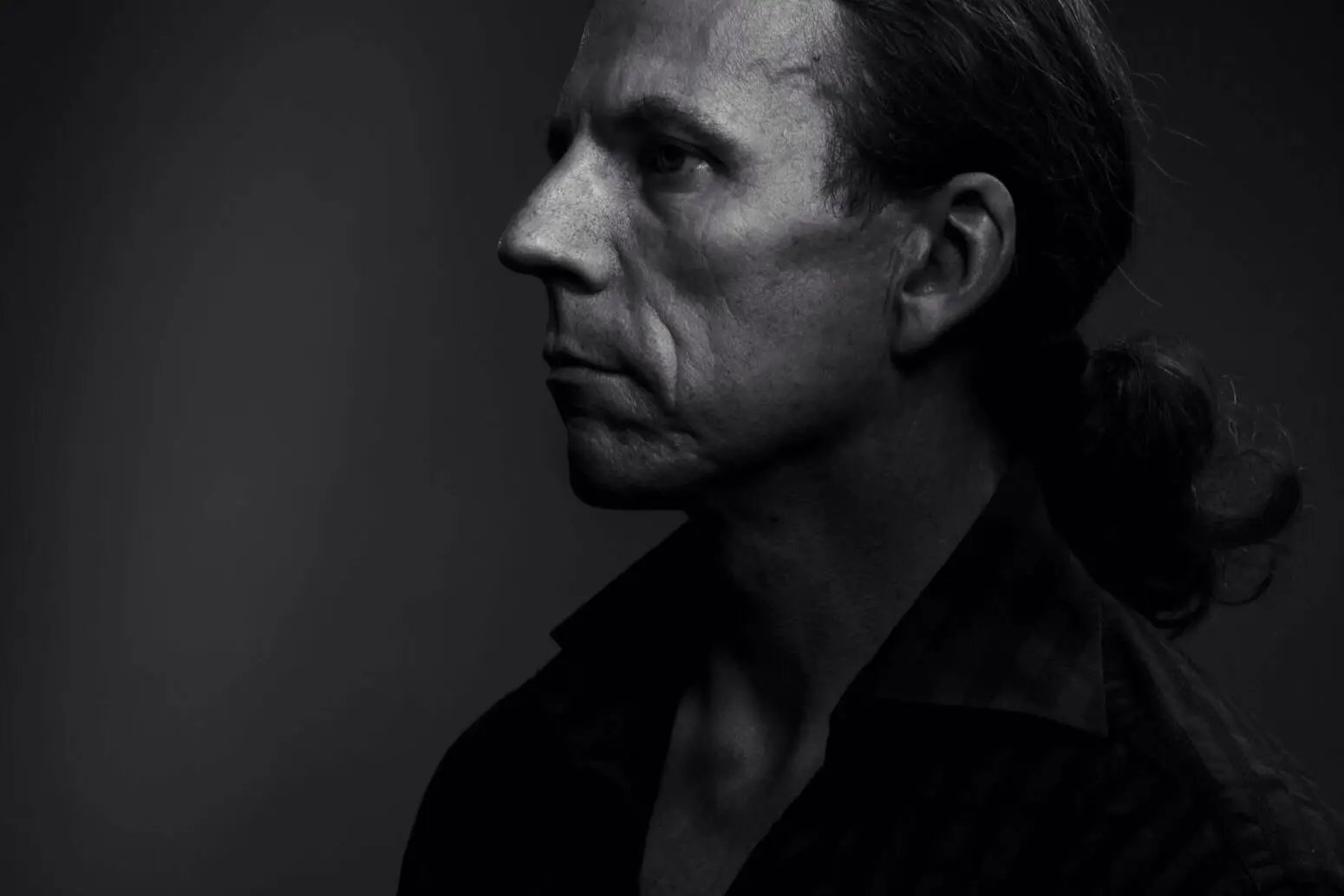 En mann med langt hår i hestehale