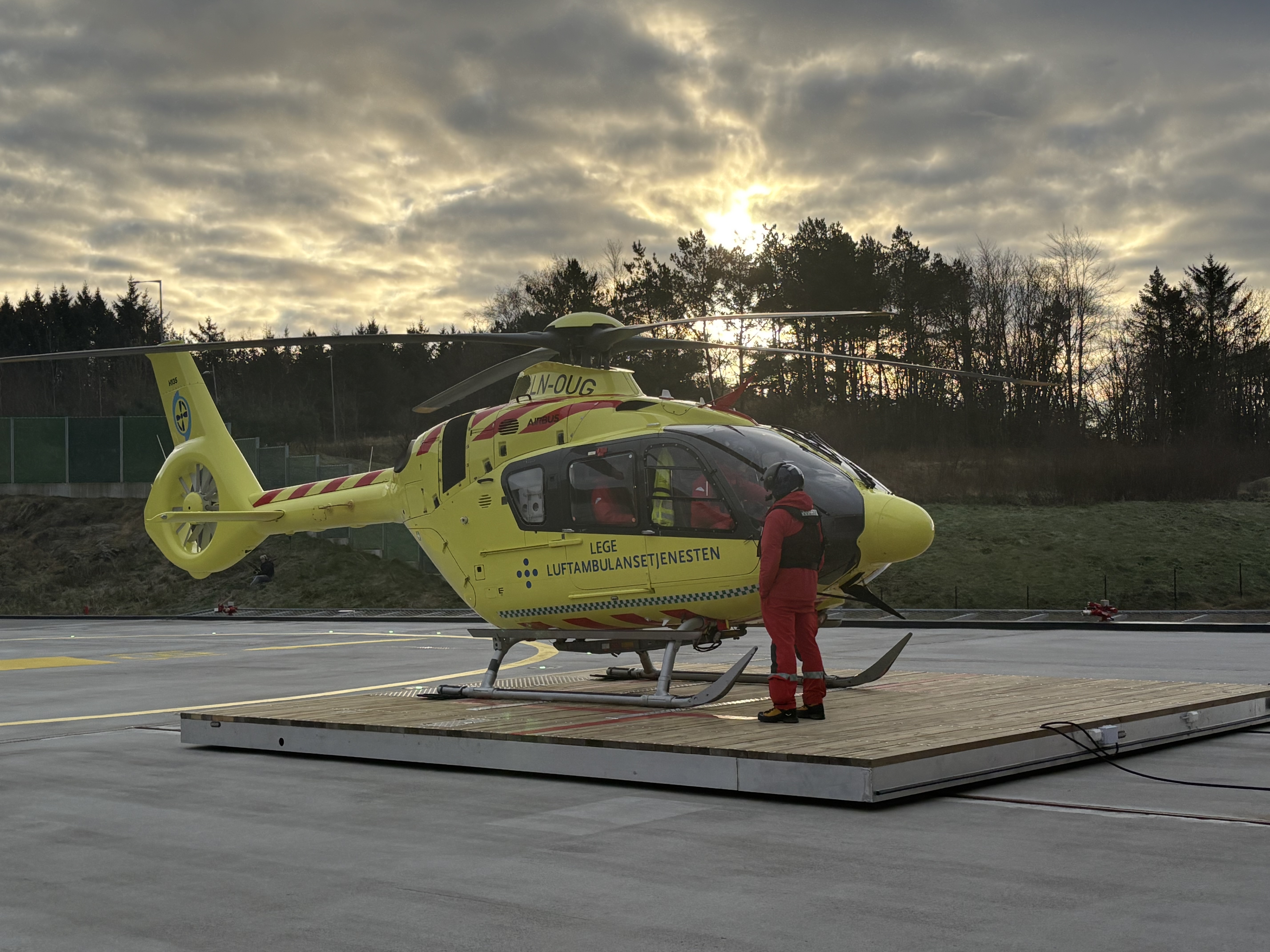 En person som står ved siden av et gult helikopter