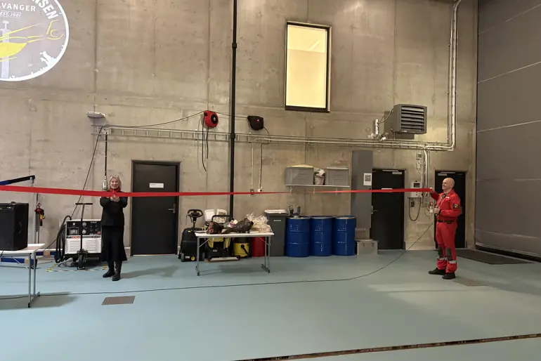 En dame klipper over en rød snor som en mann holder