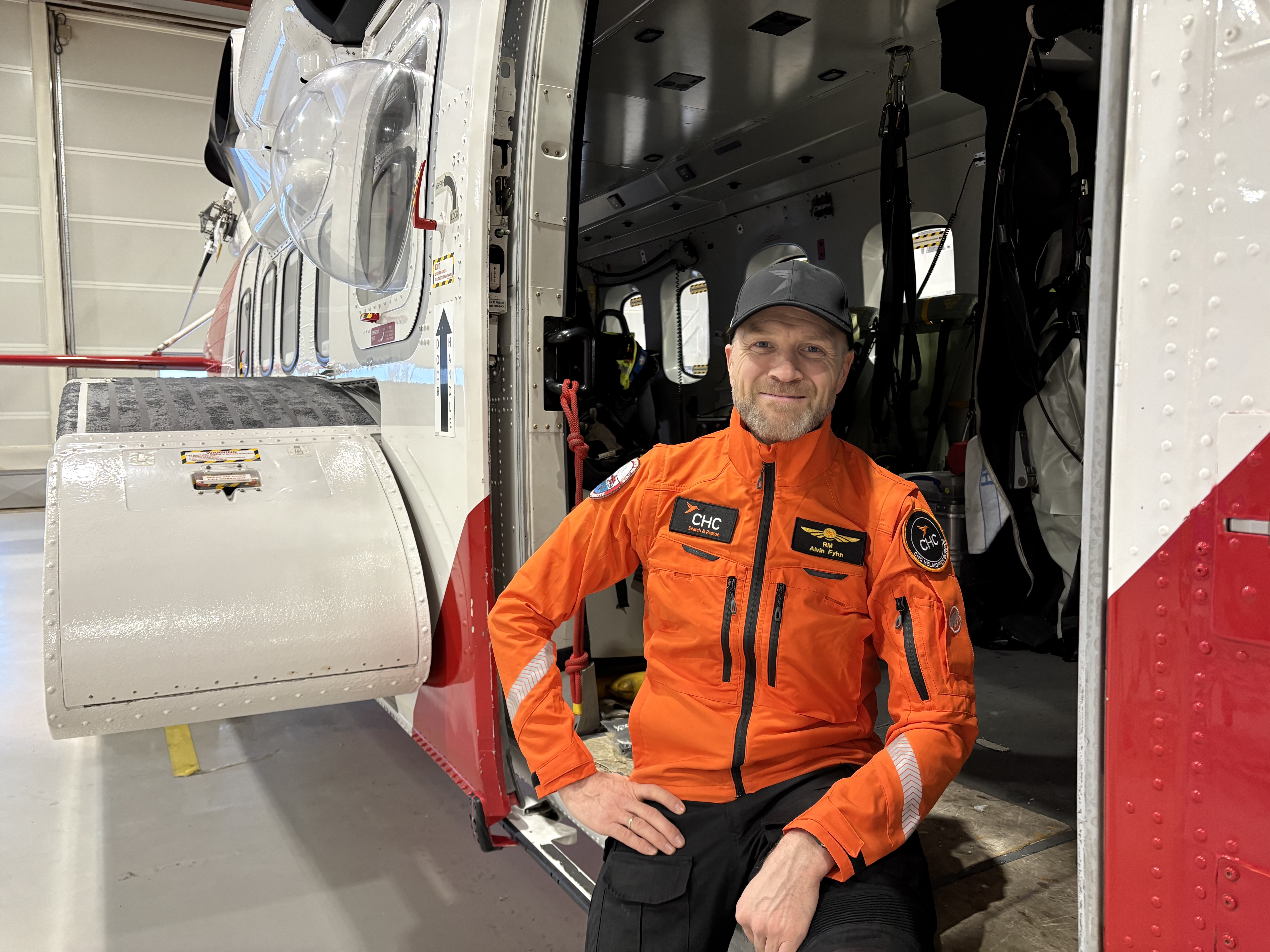 Smilende mann i døra på et redningshelikopter