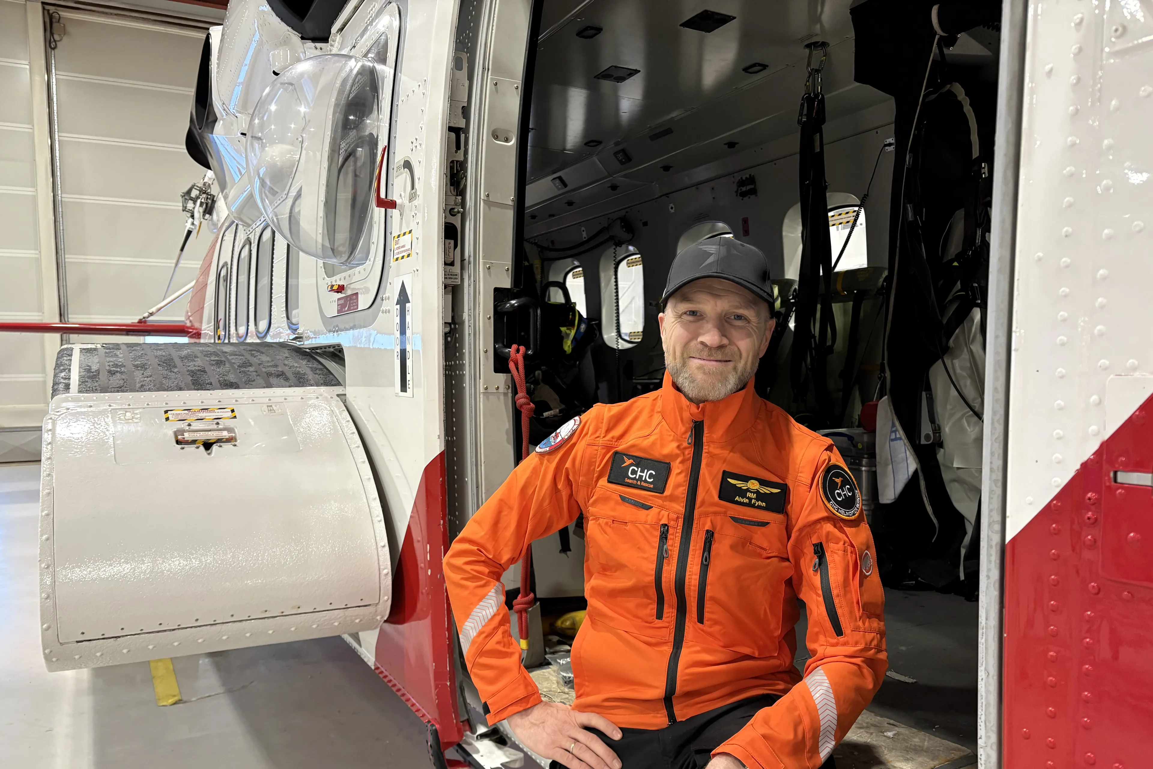 Smilende mann i døra på et redningshelikopter