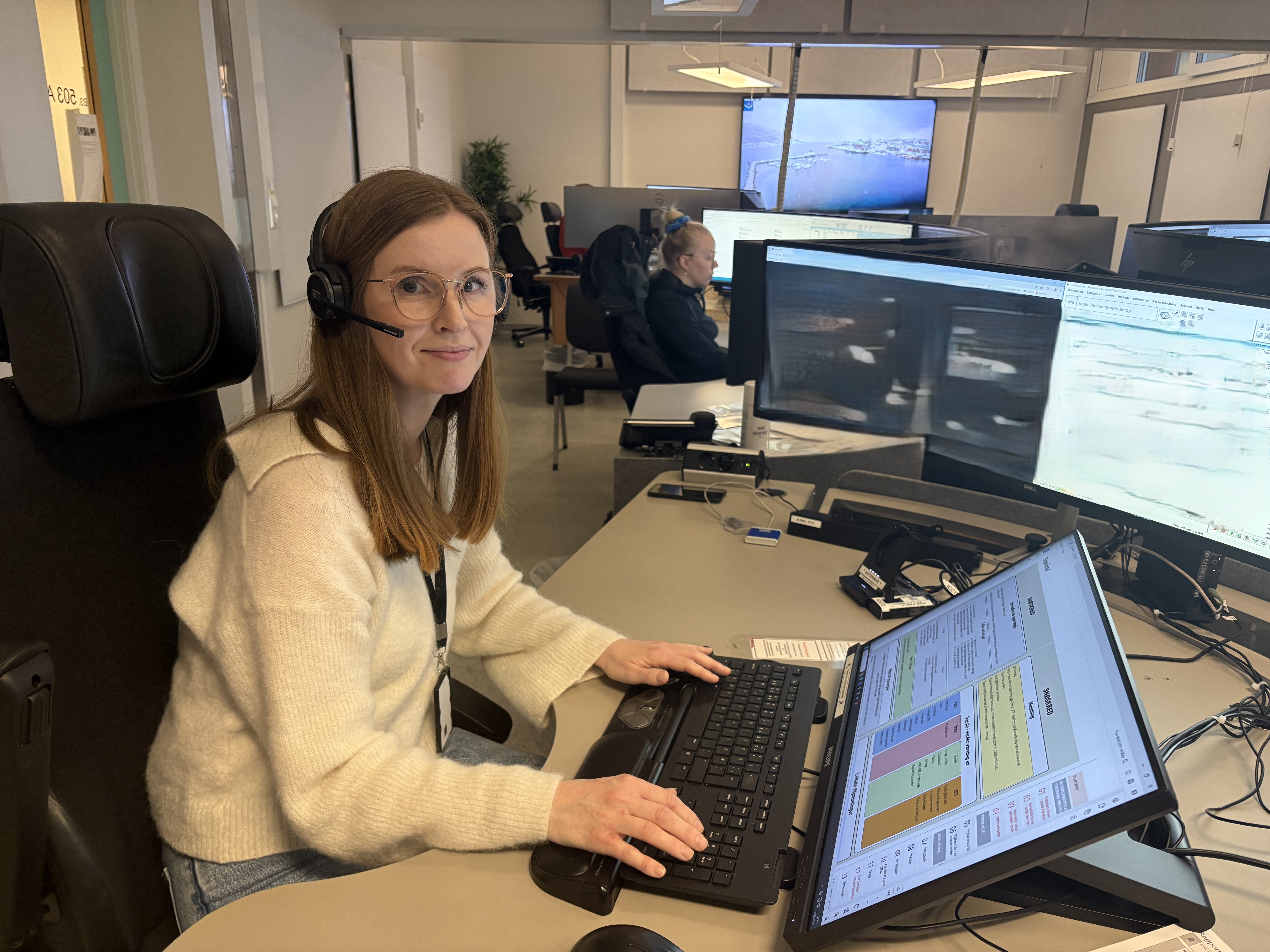 En person som sitter ved et skrivebord med en datamaskin