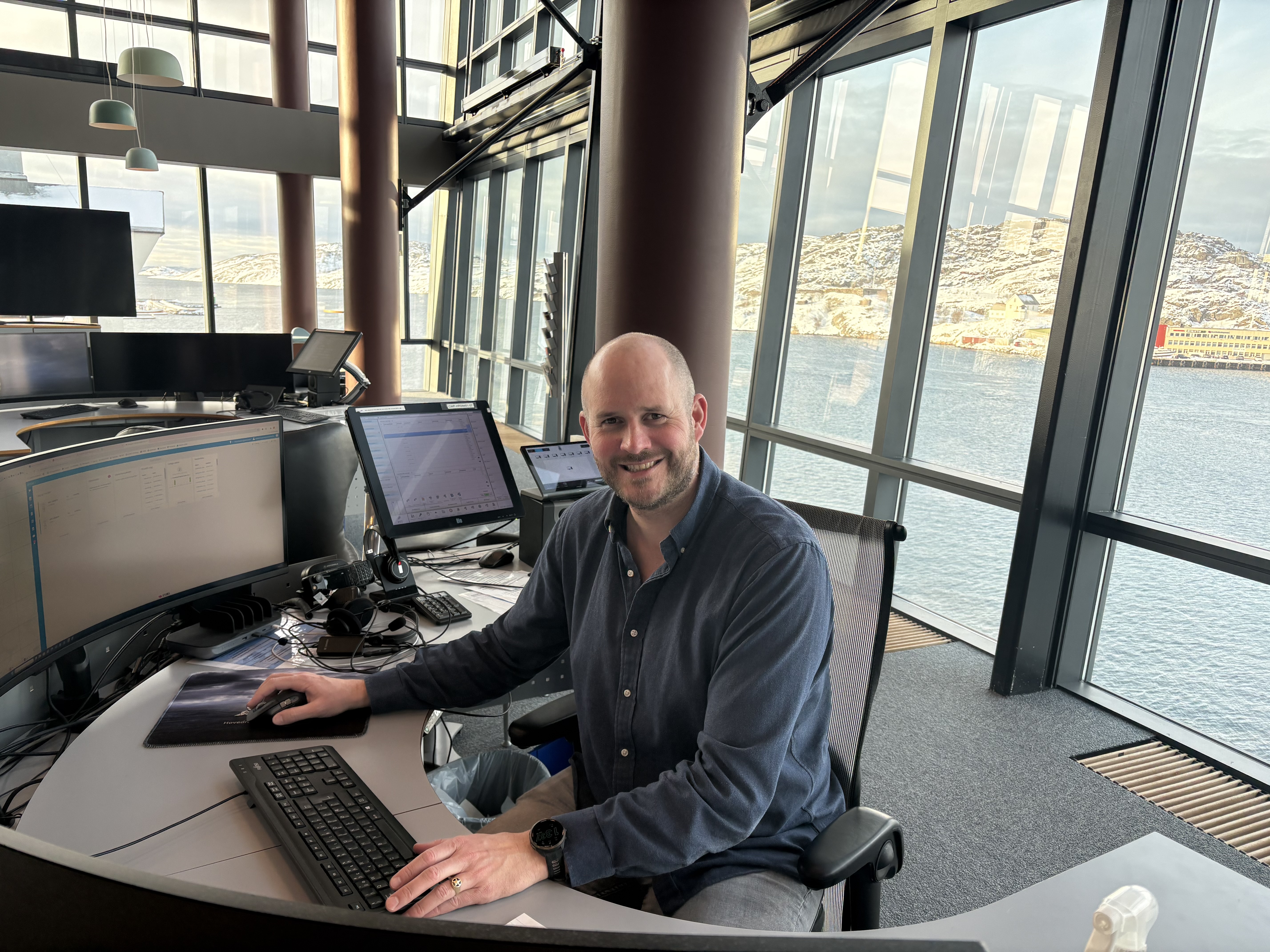 En smilende mann i en operatsjonssentral