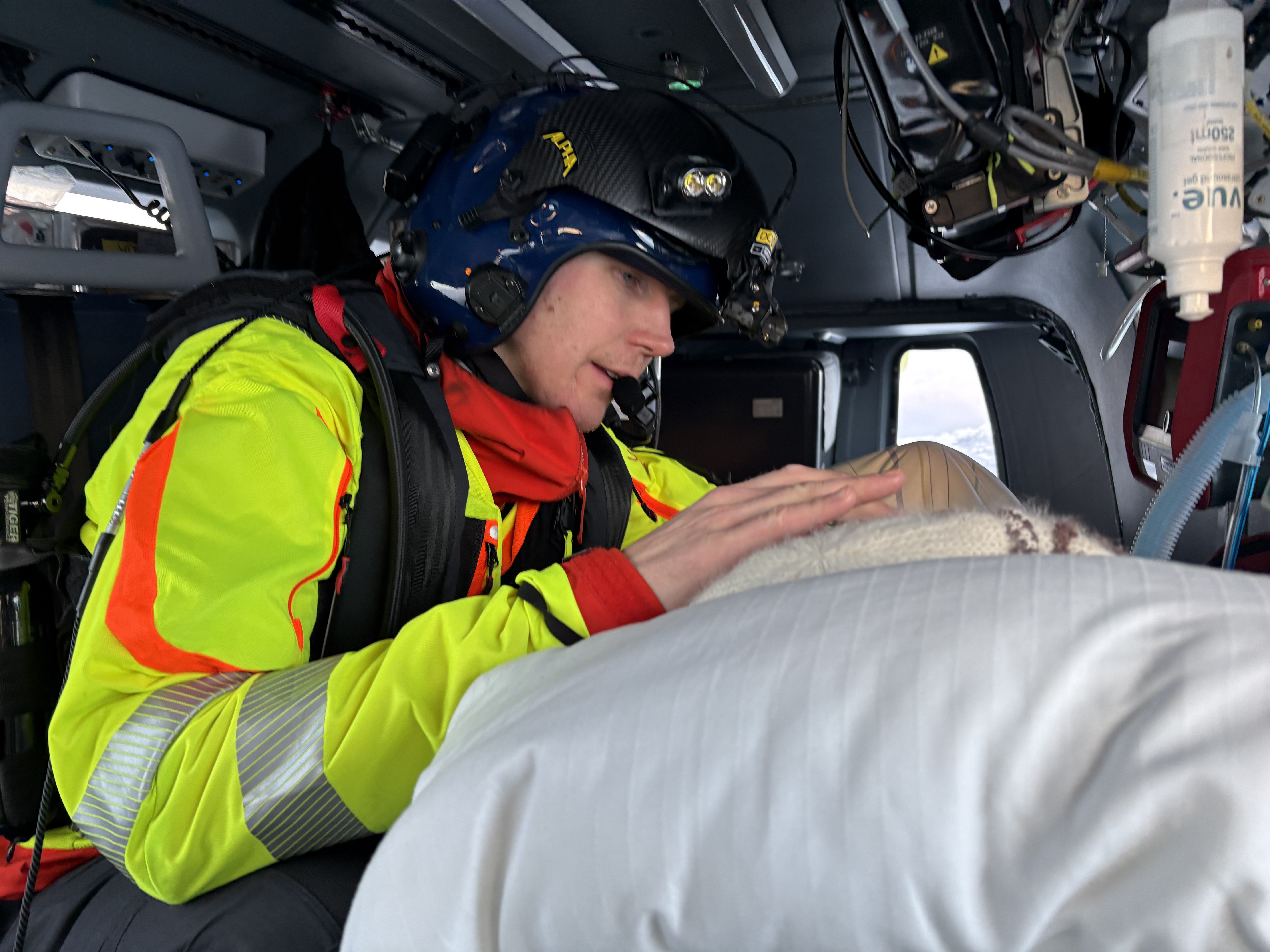 En lege har omsorg for pasient i helikopter