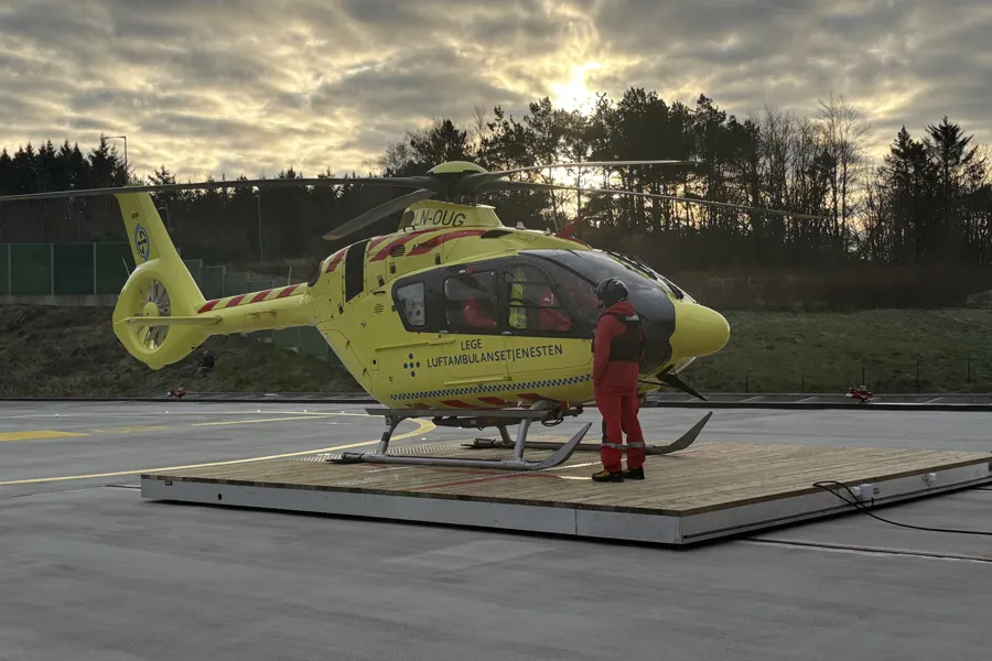 En person som står ved siden av et gult helikopter