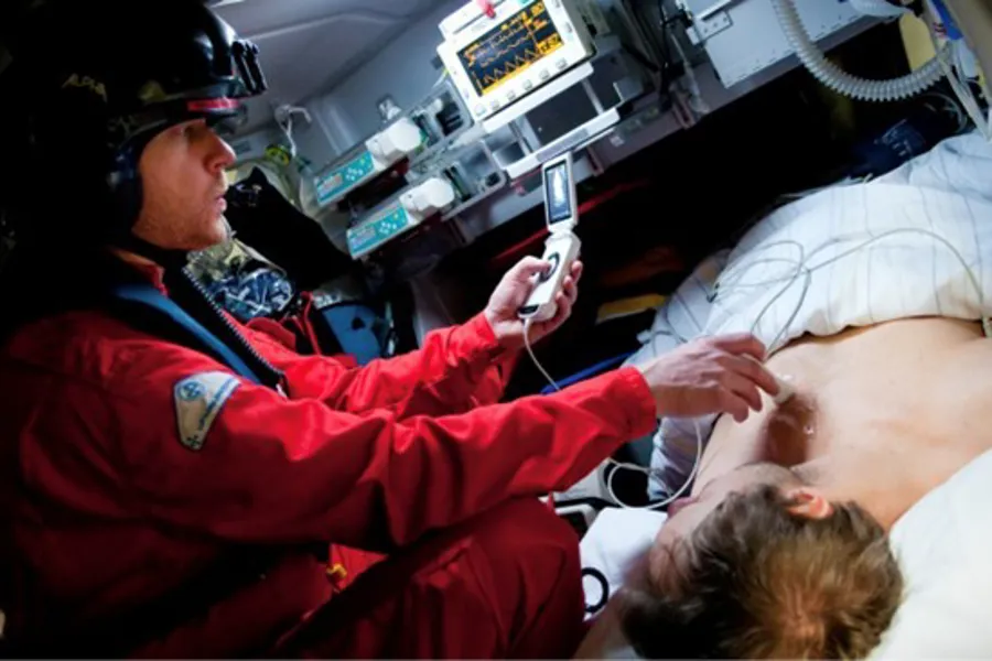 En lege pleier en pasient i et helikopter