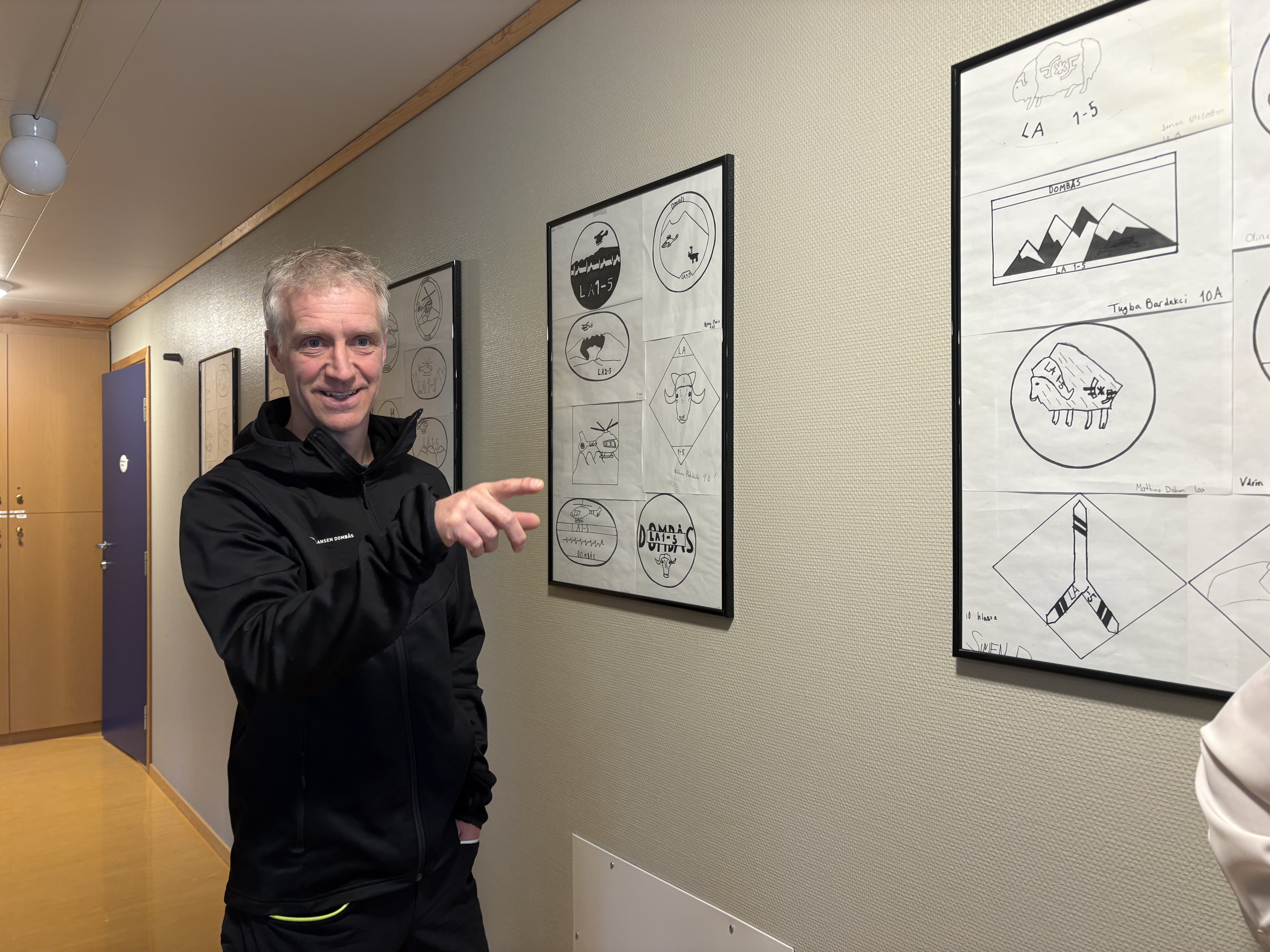 Mann foran en vegg av barnetegninger