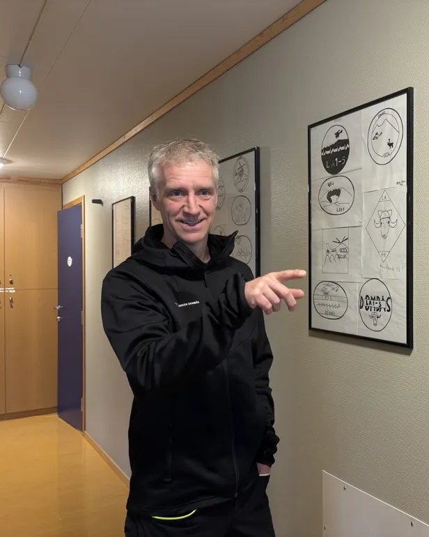 Mann foran en vegg av barnetegninger