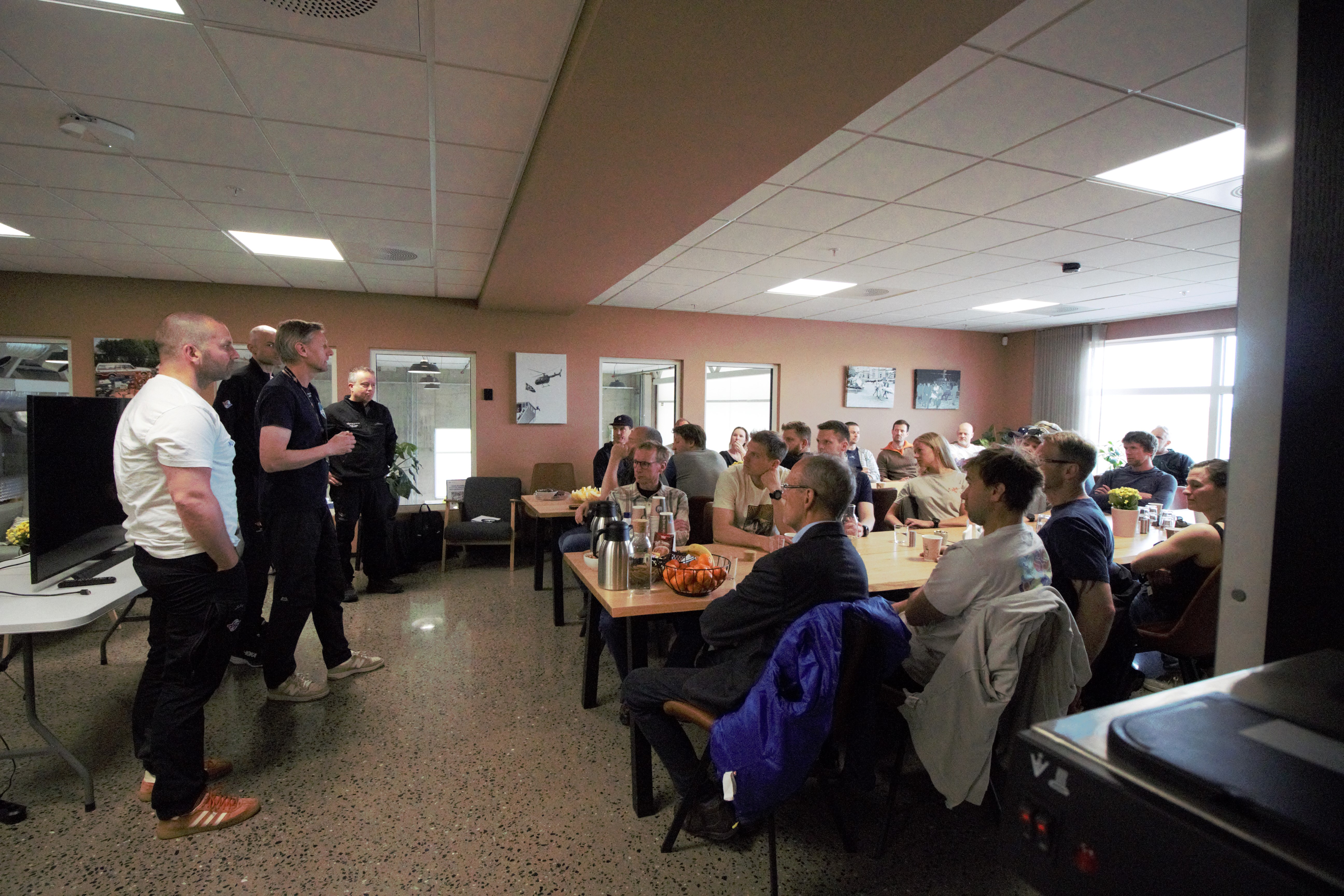 Tre menn  foreleser foran mange redningsmenn