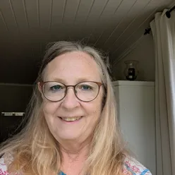 En dame med briller som smiler