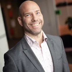 En mann som smiler til kameraet