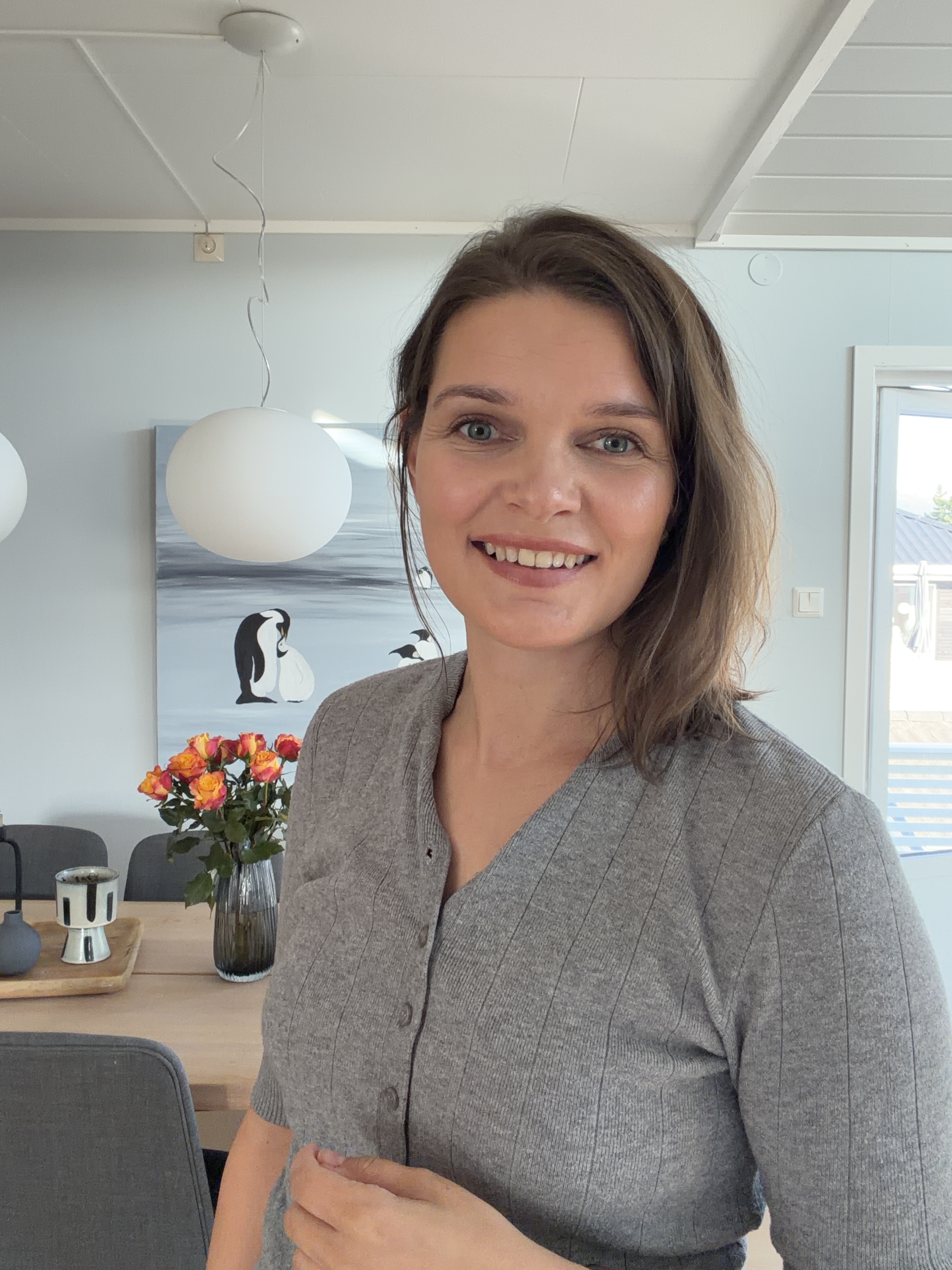 En kvinne som smiler til kameraet