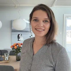 En kvinne som smiler til kameraet