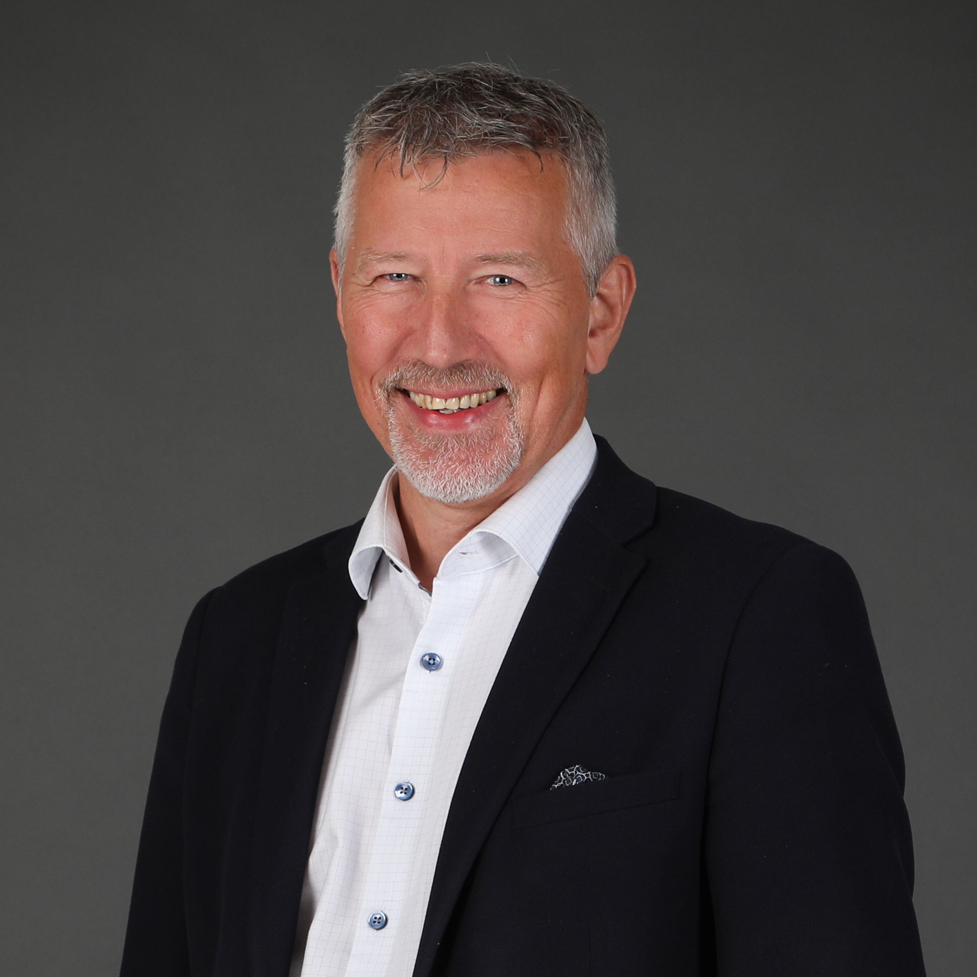 En mann som smiler til kameraet