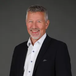 En mann som smiler til kameraet