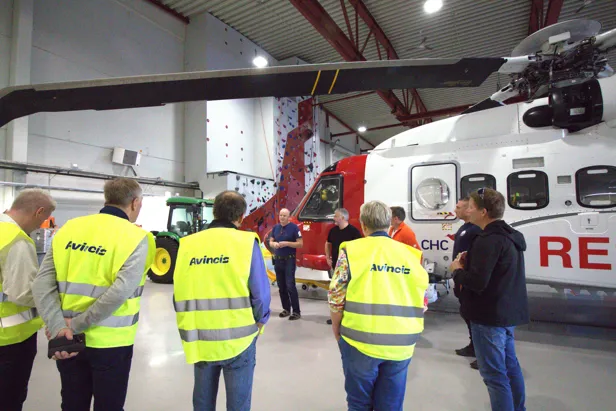 En gruppe mennesker foran et hvit redningshelikopter