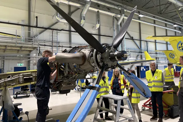 En mann skrur på en flypropell med tilhørere rundt