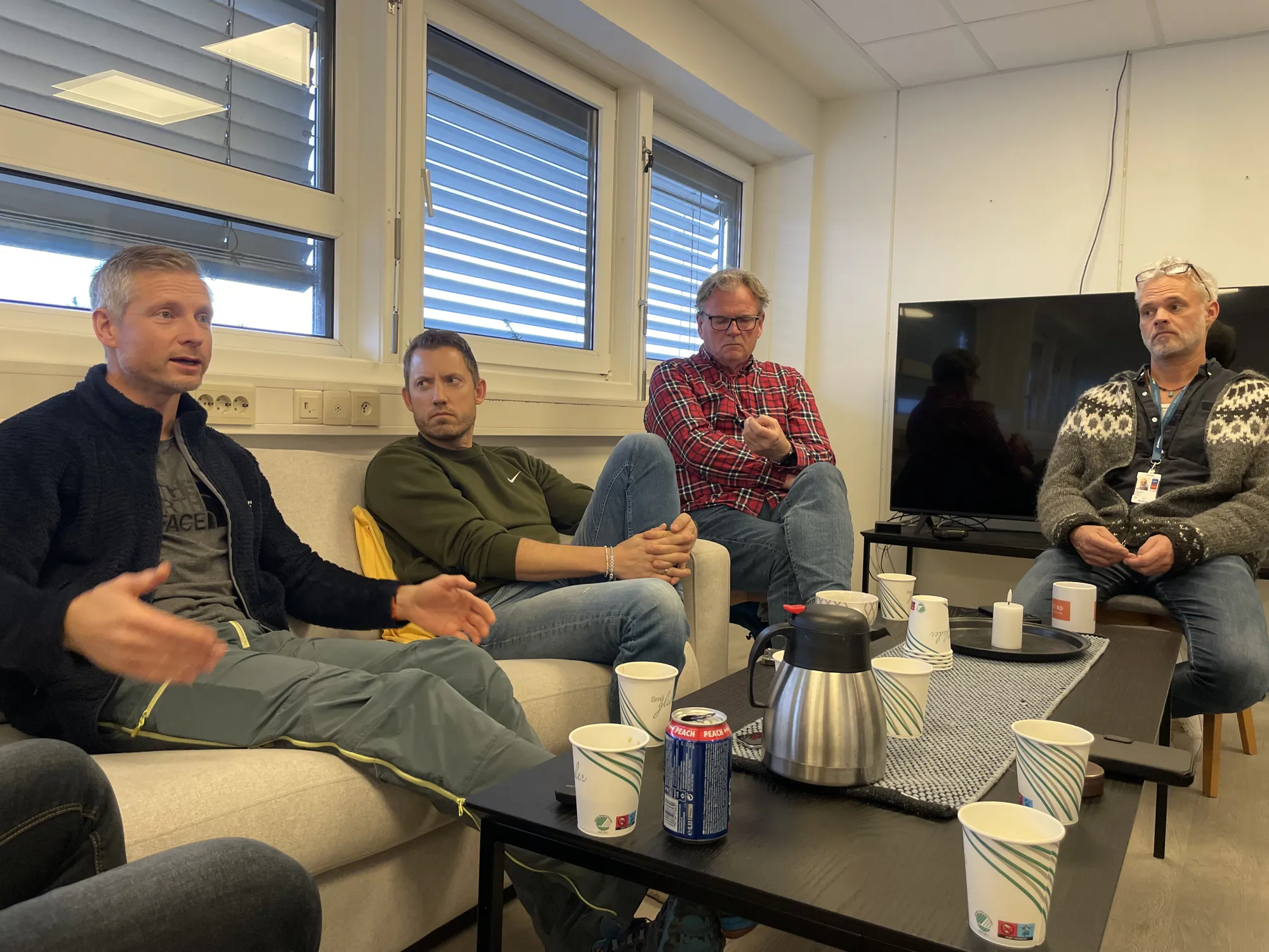 En gruppe menn som sitter i et rom
