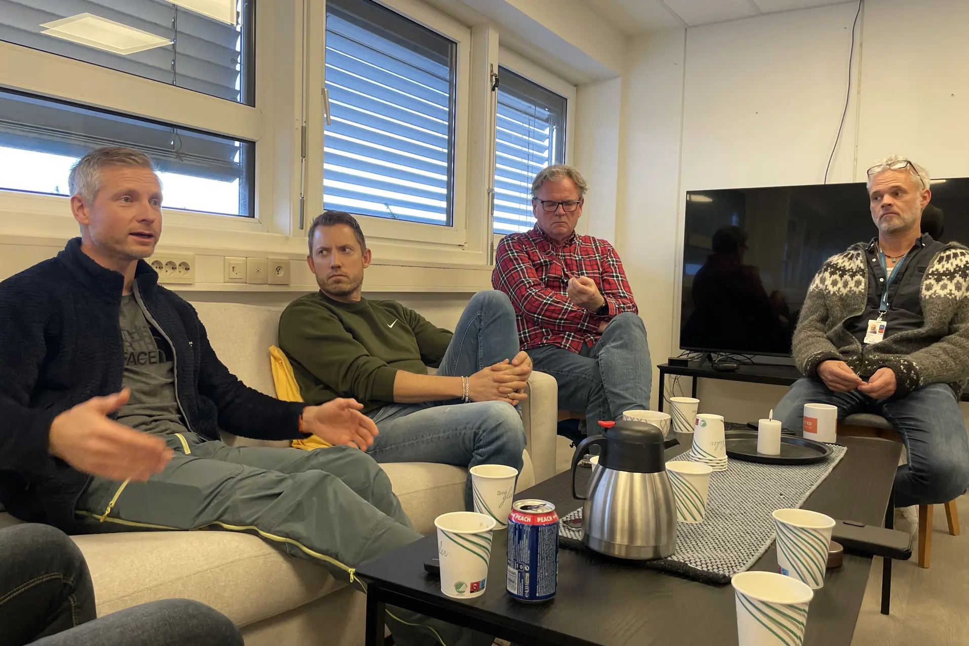 En gruppe menn som sitter i et rom