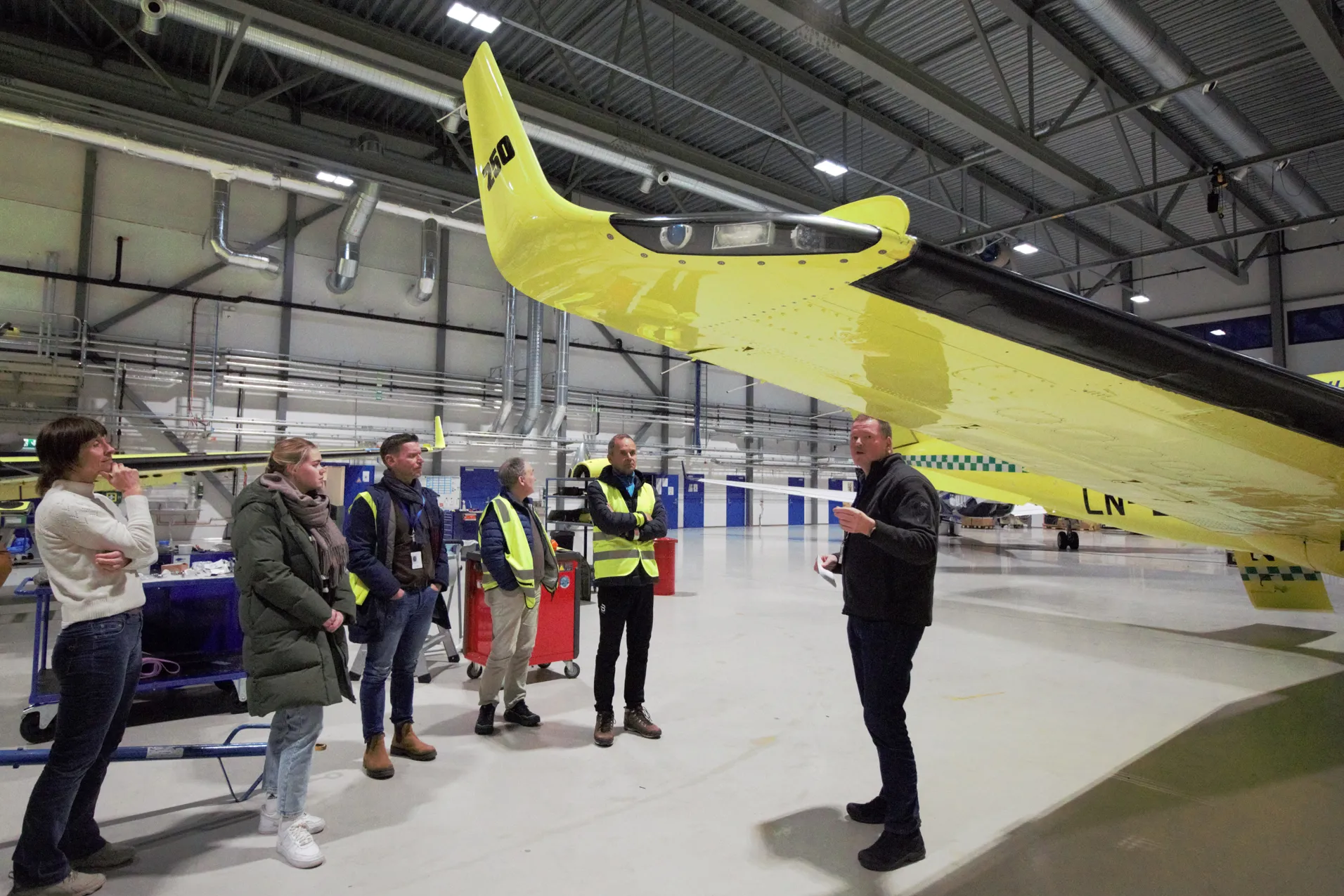 En gruppe mennesker rundt en fly-vinge