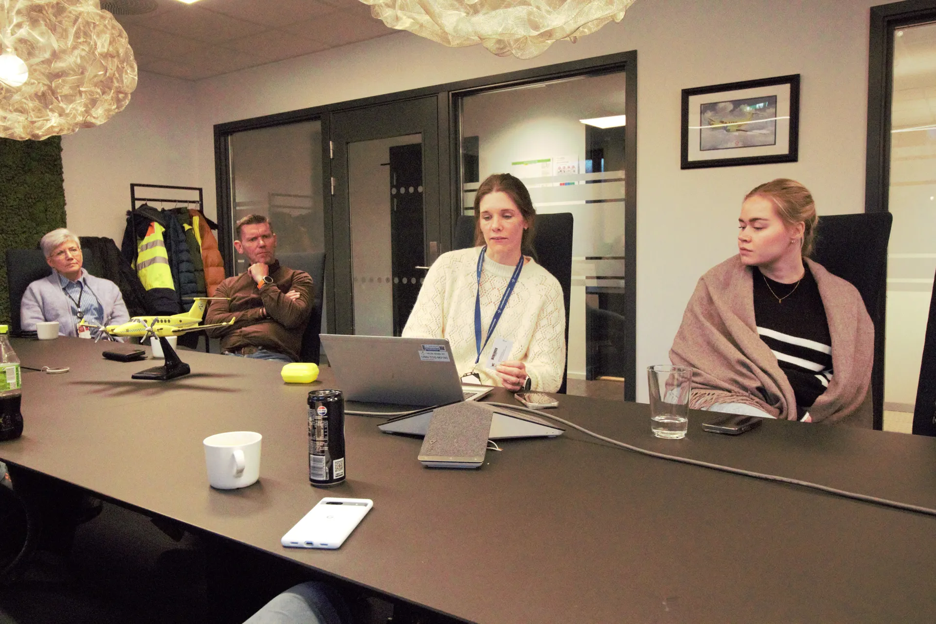 Fire mennesker sitter rundt et møtebord