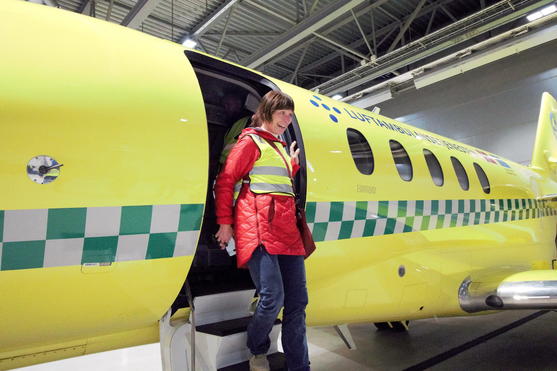 Smilende dame kommer ut av et fly