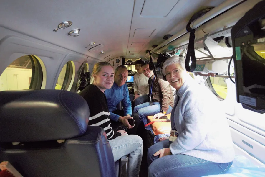 En gruppe mennesker sitter inne i et lite fly